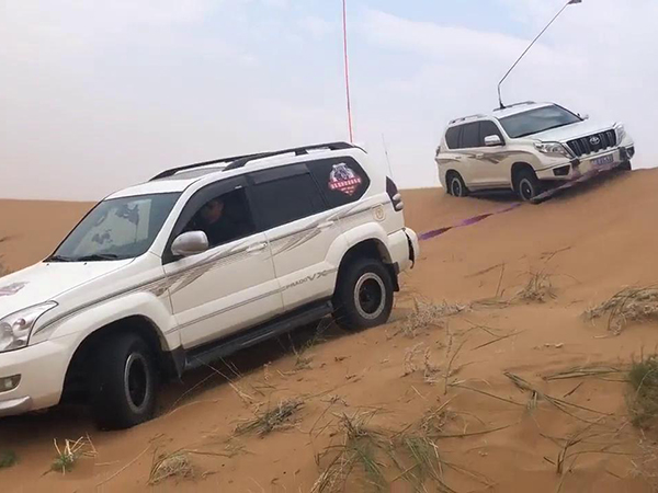 沙地救援現(xiàn)場：拖車如何將陷車“拔出”泥潭